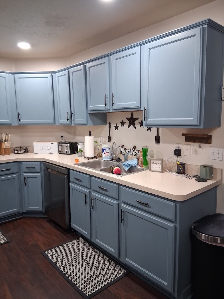 Blue-gray painted shaker kitchen cabinets with dark hardware — cabinet refinishing project in Utah