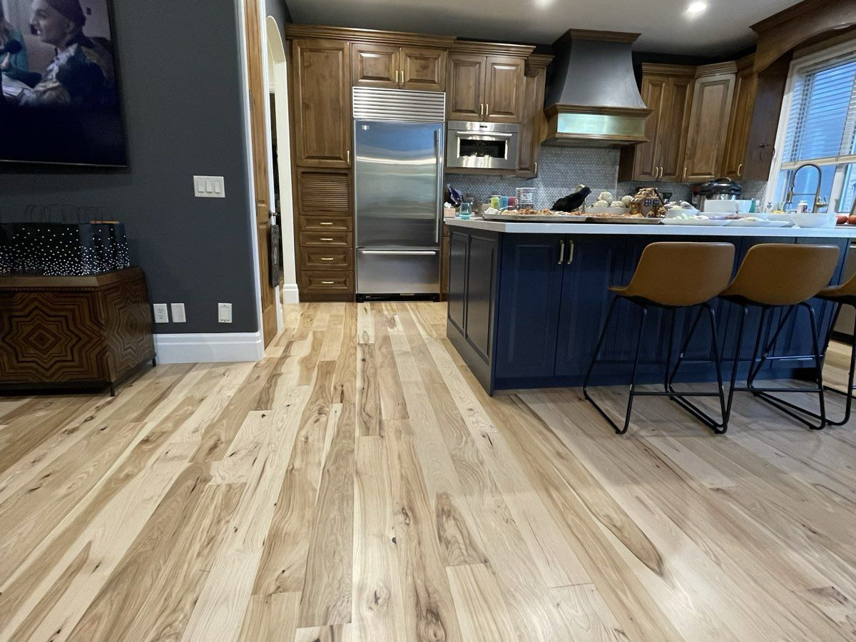 Open-concept kitchen with deep navy painted island, dark gray accent wall, and wood-beamed ceiling — interior painting project in Utah